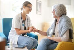 Doctor Holding Hand of Elderly Woman Patient